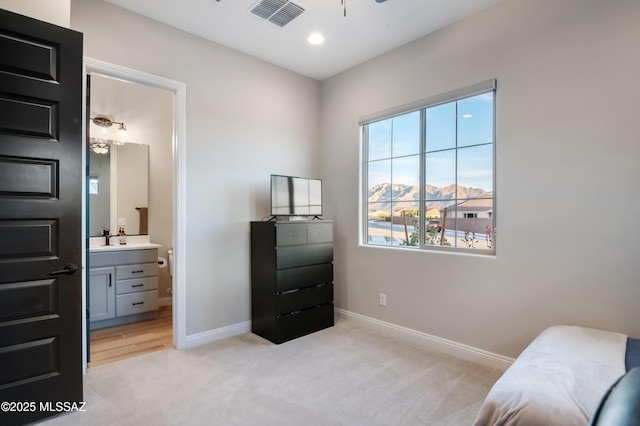 bedroom with a mountain view, light carpet, and sink