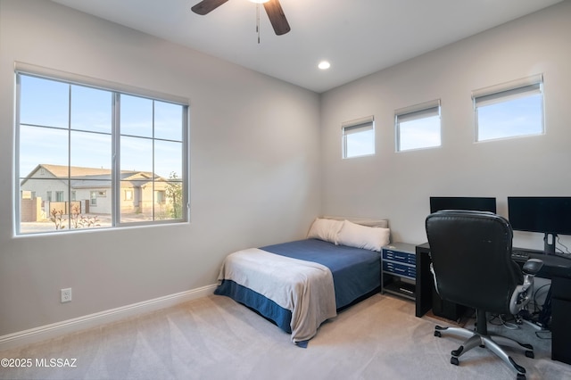 carpeted bedroom featuring multiple windows and ceiling fan