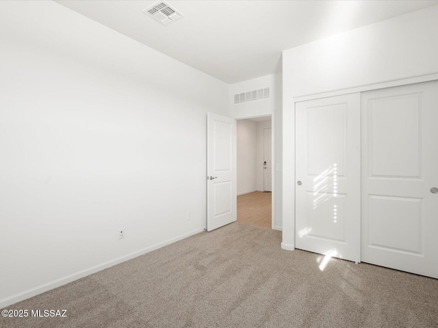 unfurnished bedroom with baseboards, a closet, visible vents, and carpet flooring