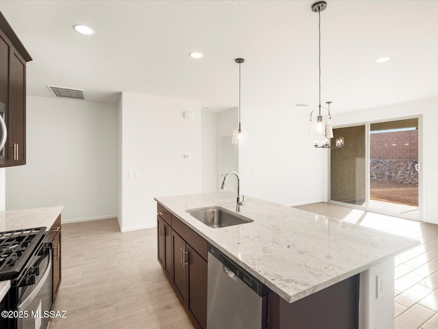 kitchen with range with gas stovetop, visible vents, a sink, dark brown cabinets, and dishwasher