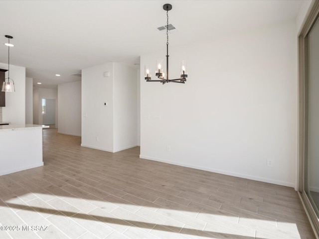 interior space with light wood finished floors, baseboards, visible vents, and an inviting chandelier