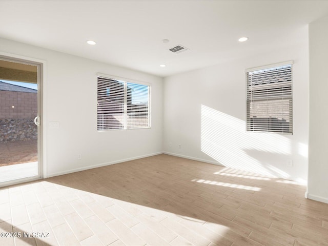 empty room featuring recessed lighting, baseboards, visible vents, and light wood finished floors