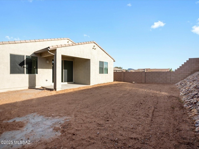 back of house with a patio, a fenced backyard, and stucco siding