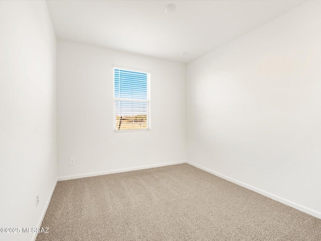 carpeted empty room featuring baseboards