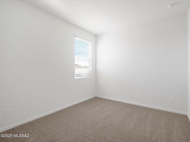 empty room featuring carpet flooring and baseboards