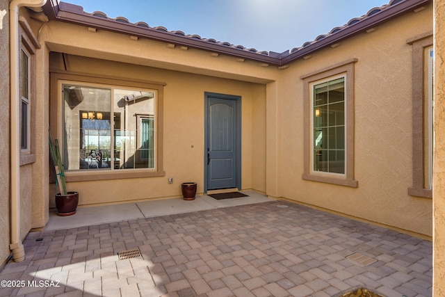 view of exterior entry with a patio