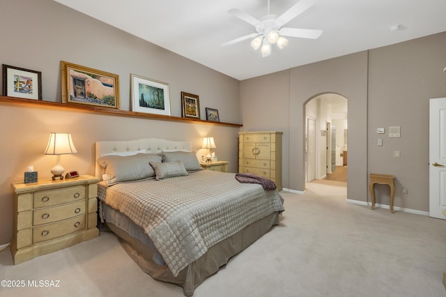63111 E Mountain Crest Dr, Tucson, AZ 85739 - bedroom featuring arched walkways, light colored carpet, baseboards, and ceiling fan