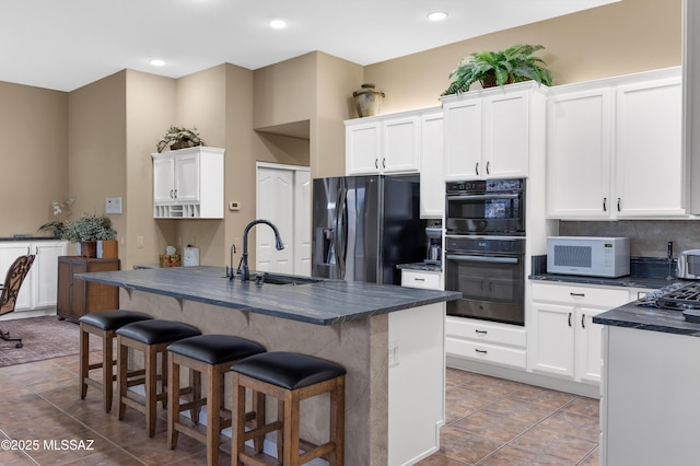 63111 E Mountain Crest Dr, Tucson, AZ 85739 - kitchen featuring black appliances, a sink, dark countertops, tile patterned flooring, and white cabinetry