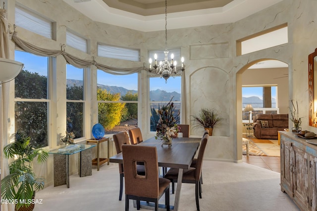 63111 E Mountain Crest Dr, Tucson, AZ 85739 - dining space with a mountain view, arched walkways, a towering ceiling, a chandelier, and light carpet