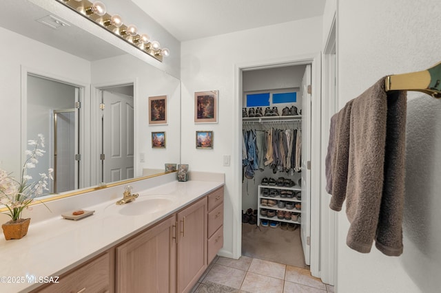 63111 E Mountain Crest Dr, Tucson, AZ 85739 - full bath with vanity, tile patterned flooring, a shower stall, and a walk in closet