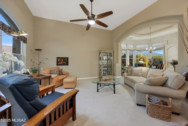 63111 E Mountain Crest Dr, Tucson, AZ 85739 - carpeted living area featuring a chandelier, a ceiling fan, baseboards, and arched walkways