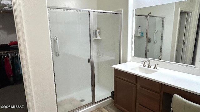 bathroom with a shower with door and vanity