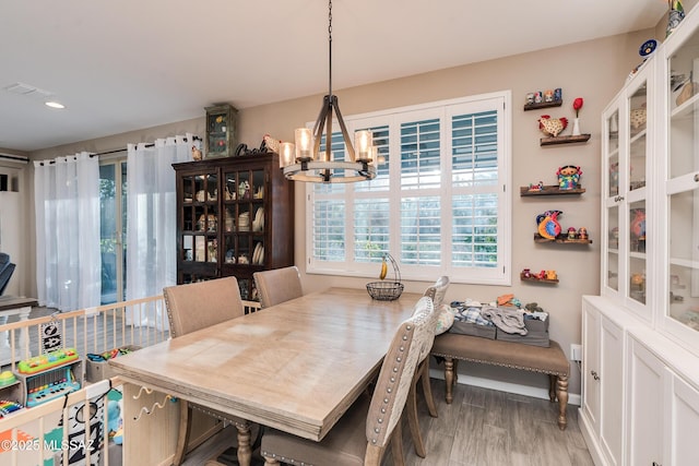 dining area with a chandelier and light hardwood / wood-style flooring