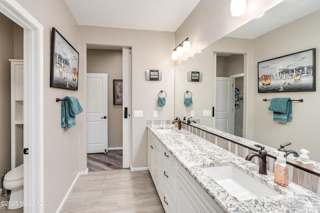 bathroom with hardwood / wood-style floors, toilet, and vanity