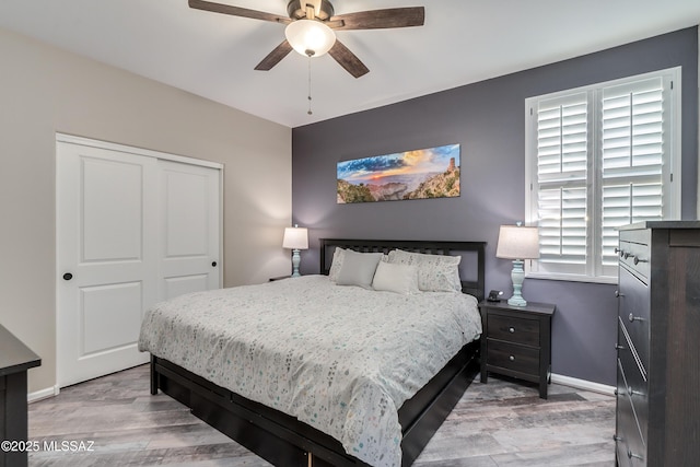 bedroom featuring light hardwood / wood-style floors, a closet, and ceiling fan