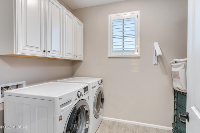 laundry area featuring cabinets, light wood-type flooring, and separate washer and dryer