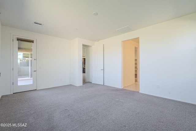 unfurnished bedroom with visible vents, light carpet, and baseboards