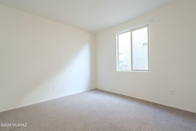 carpeted spare room with baseboards