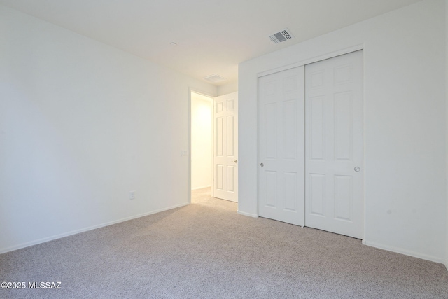 unfurnished bedroom with carpet floors, a closet, visible vents, and baseboards