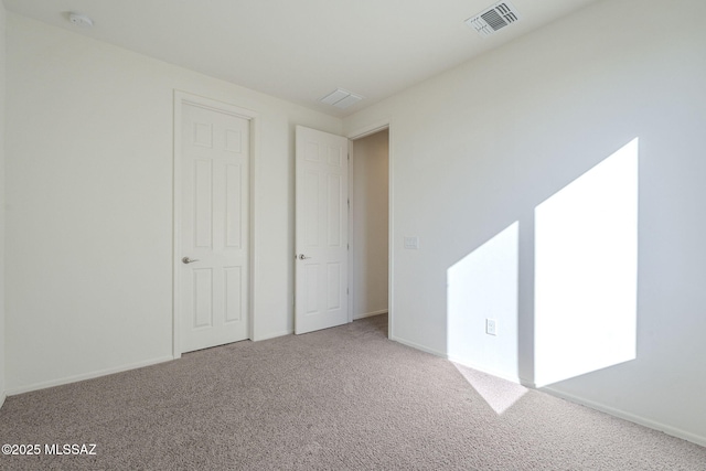 unfurnished bedroom with carpet, visible vents, and baseboards