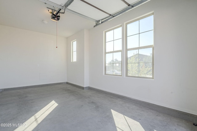 garage featuring a garage door opener and baseboards