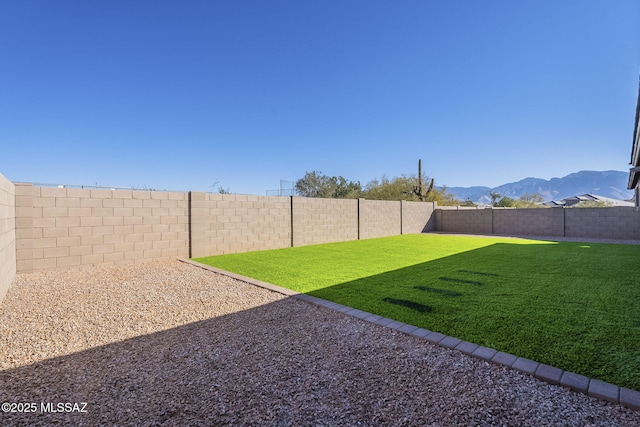 view of yard with a fenced backyard and a mountain view