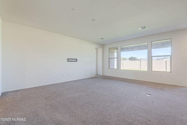 unfurnished room featuring light carpet, visible vents, and baseboards