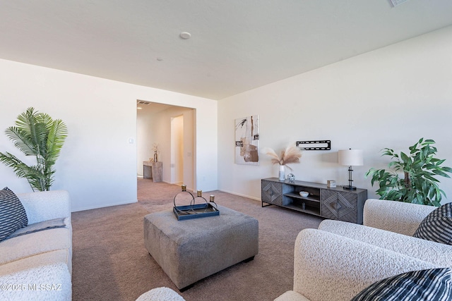 carpeted living area featuring baseboards