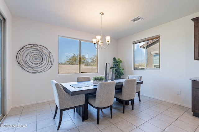 dining area with light tile patterned floors, baseboards, visible vents, and a chandelier