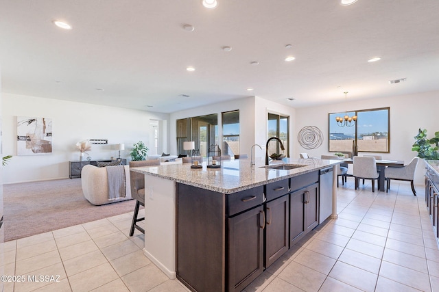 kitchen with light tile patterned flooring, light carpet, a sink, visible vents, and stainless steel dishwasher