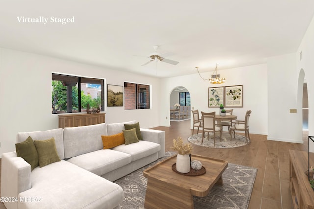 living room featuring hardwood / wood-style floors and ceiling fan with notable chandelier