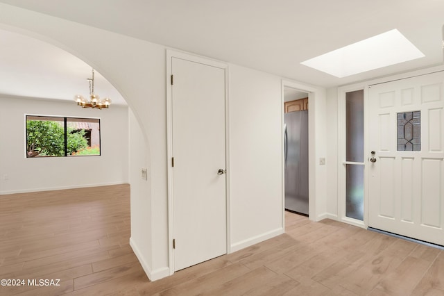 entryway featuring a chandelier, a skylight, and light hardwood / wood-style flooring