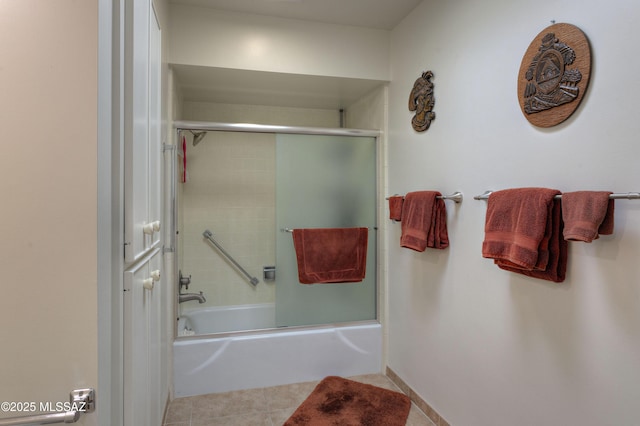 bathroom featuring bath / shower combo with glass door and tile patterned floors