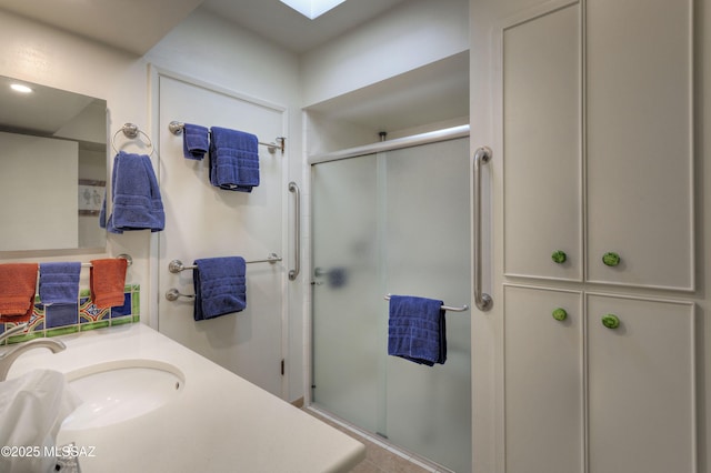 bathroom featuring a skylight, vanity, and walk in shower