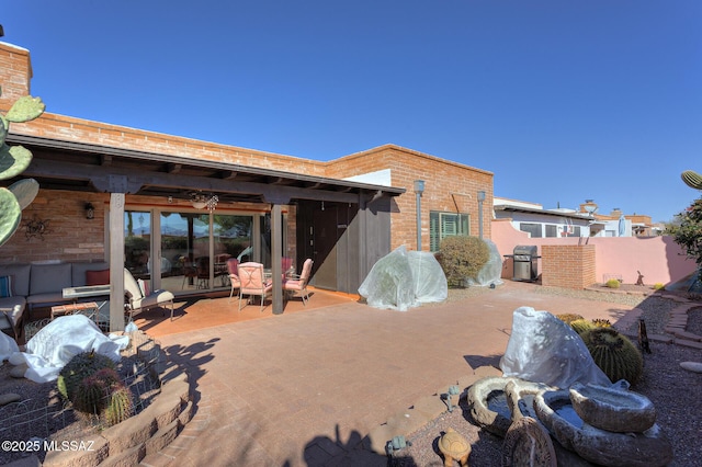 back of house featuring an outdoor living space and a patio