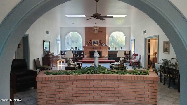 interior space featuring high vaulted ceiling, a skylight, a healthy amount of sunlight, and visible vents