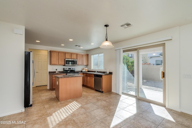 kitchen with pendant lighting, a center island, light tile patterned flooring, and appliances with stainless steel finishes