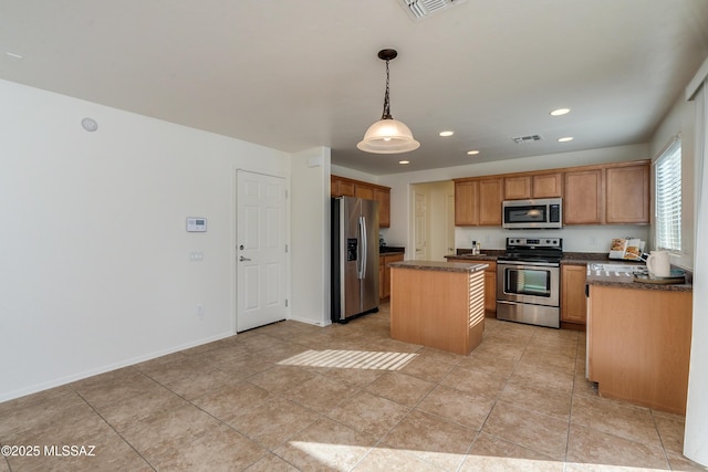 kitchen featuring decorative light fixtures, a center island, light tile patterned flooring, and appliances with stainless steel finishes