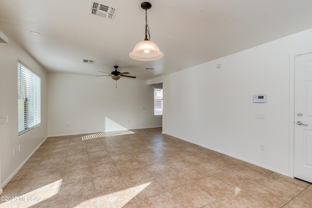 tiled spare room with ceiling fan