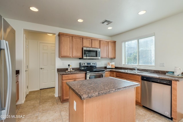 kitchen featuring light tile patterned floors, a center island, stainless steel appliances, and sink