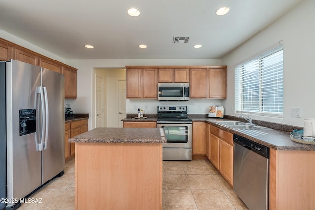 kitchen featuring a center island, sink, light tile patterned floors, and stainless steel appliances