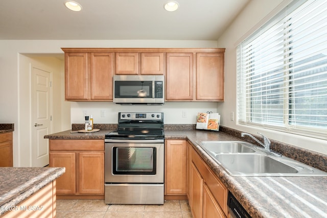 kitchen with light tile patterned floors, stainless steel appliances, and sink