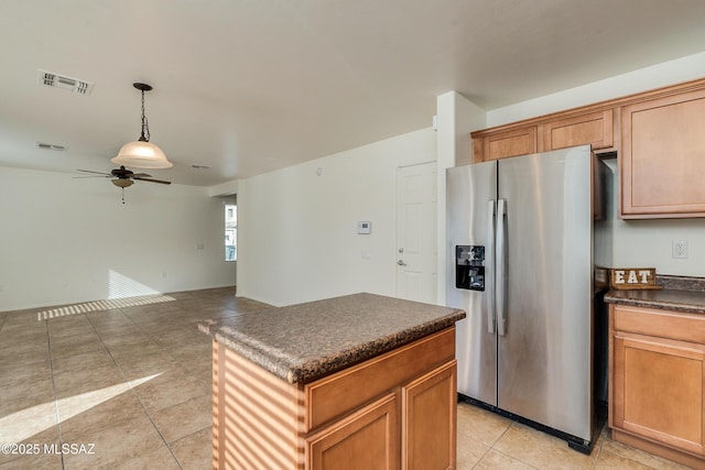 kitchen featuring ceiling fan, a center island, stainless steel fridge with ice dispenser, pendant lighting, and light tile patterned floors