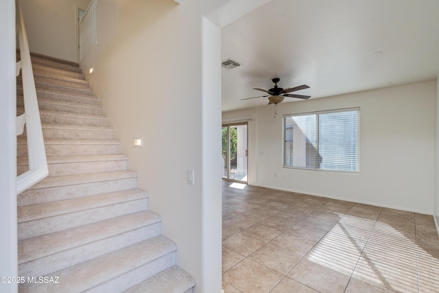 stairs featuring tile patterned flooring and ceiling fan