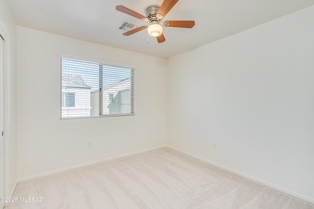 spare room with light colored carpet and ceiling fan