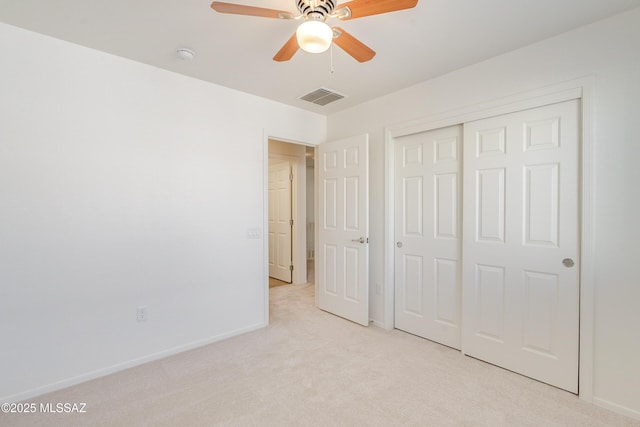 unfurnished bedroom featuring ceiling fan, light carpet, and a closet