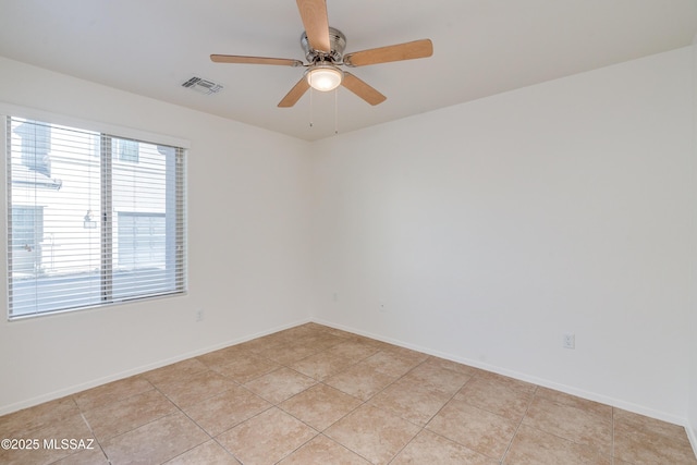 tiled spare room with ceiling fan