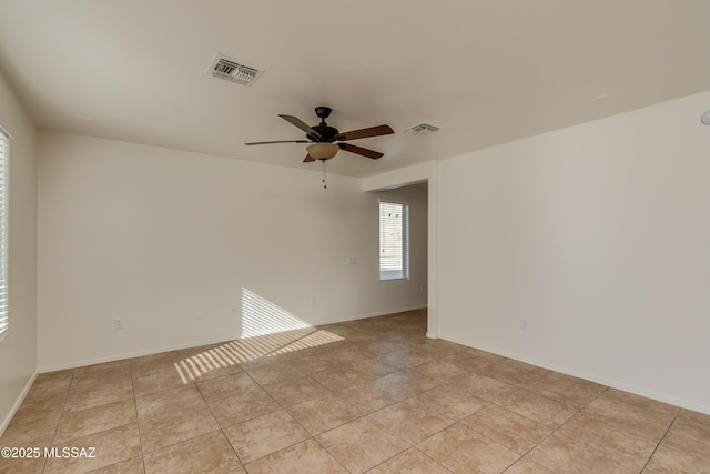 tiled spare room featuring ceiling fan