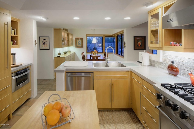 kitchen featuring appliances with stainless steel finishes, wall chimney exhaust hood, sink, light brown cabinets, and light tile patterned floors