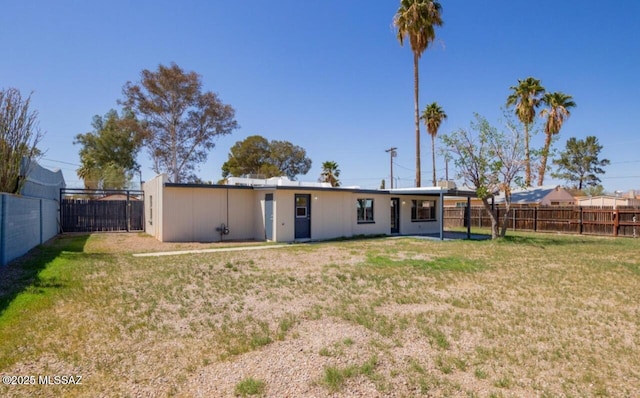 back of house featuring a lawn and a fenced backyard